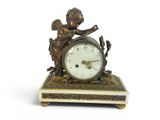 a small clock with a statue on top of it