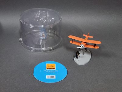 un petit avion miniature posé à côté d'un récipient en plastique
