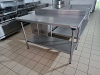 1 table en inox avec tablette d'entretoise, adossée TOURNUS …