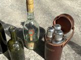 three bottles of alcohol and a case of salt and pepper shakers on the ground