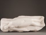 a white sculpture of a woman laying on a pillow