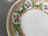 two cups and saucers with flowers on them sitting on a table
