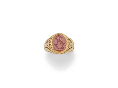 une bague en or avec une pierre rouge au centre