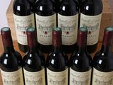 several bottles of red wine are lined up on a table