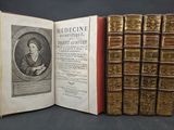 un livre ouvert sur lequel figure l'image d'une femme assise devant une rangée de livres
