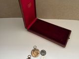 a small wooden box with a bunch of coins in it