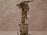 une image représentant une sculpture représentant la tête d'un homme posée sur un rocher