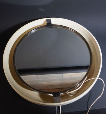 a round mirror on the wall next to a table