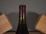 a bottle of wine sitting on a table next to a block of wood