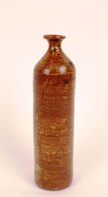 a brown vase that is sitting on a white surface