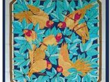 une photo d'une broderie au point de croix représentant des oiseaux et des feuilles