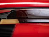 the interior of a red sports car with a steering wheel and dashboard