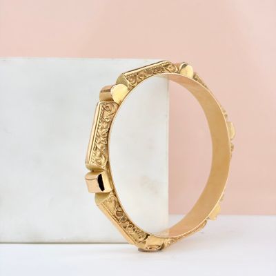 a close up of a gold watch on a marble surface