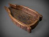 an old wooden bowl with a wooden handle on a gray surface
