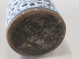a close up of a vase on a white surface