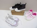 trois paires de chaussures posées sur une table à côté d'une boîte
