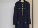 un manteau suspendu à un porte-vêtements devant un mur blanc