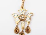 une image représentant un pendentif en or orné d'une croix et de deux larmes