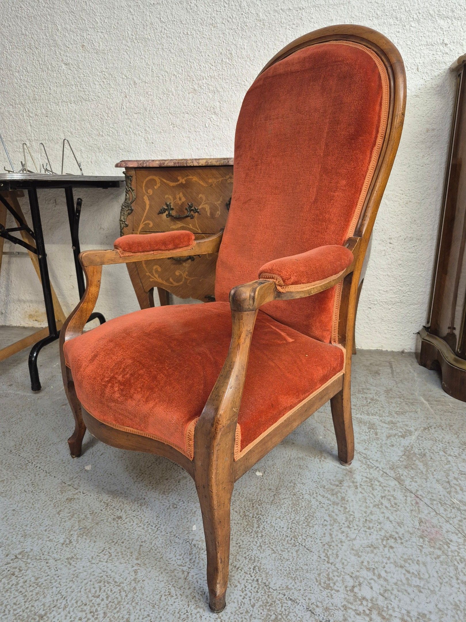 Fauteuil Voltaire en bois de placage et tissu orange.