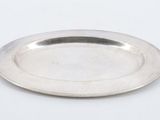 a silver plate on a white table with a white background