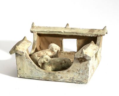 une petite statue représentant un chien dans un bateau, posée sur une surface blanche