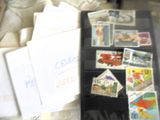 une valise noire ornée de timbres, posée sur un lit