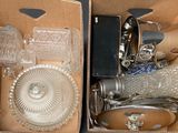 two boxes with glass items inside of them on a table