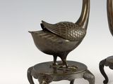 pair of bronze peacocks on stools on white background
