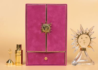 purple and gold jewelry box with a sunburst on top of it