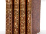 trois vieux livres sont alignés sur une surface blanche