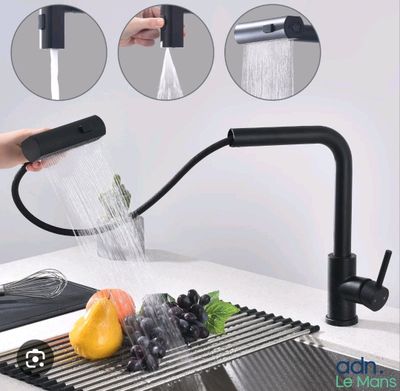 un robinet noir d'où coule de l'eau dans un évier