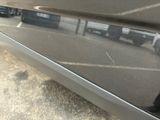 a close up of a car ' s rear bumper with a reflection of a person in it