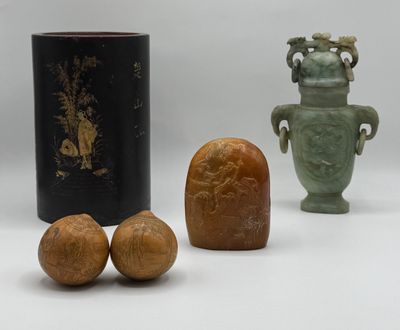 trois vases et deux noix posés sur une surface blanche, sur fond gris