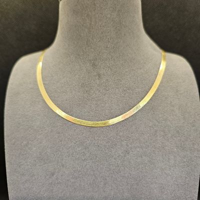 un collier plaqué or autour du cou d'un mannequin