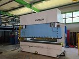 the large machine is sitting in a warehouse with a lot of windows