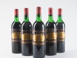 four bottles of wine are lined up on a white surface