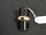 une image représentant une bague en or sertie d'une pierre bleue et d'une étiquette