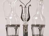 trois vases en verre posés sur un socle, avec un cœur au milieu