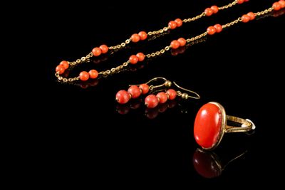 un gros plan d'un collier et de boucles d'oreilles posés sur une surface noire