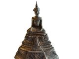 a silver statue of a buddha sitting on top of a pyramid