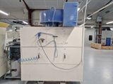 une photo d'une machine dans une usine, sur laquelle est posé un seau bleu