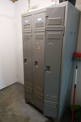 deux casiers dans une pièce, avec un balai à côté