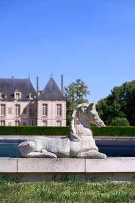 a statue of a dog that is sitting in front of a fountain
