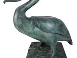 statue of a pelican standing on a base on a white background