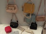 several purses are hanging on a wall next to a bed