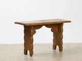 a small wooden bench on the floor in a room