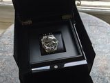 une boîte avec une montre à l'intérieur sur une table