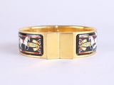 a close up of a gold bracelet with a horse on it