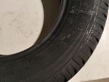 a close up of a tire on a white surface with a person standing next to it