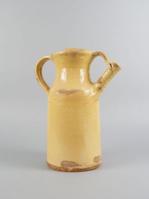 an image of a yellow vase sitting on top of a table